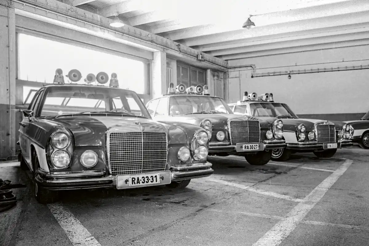 Budapest IX. kerület, Nádasdy utca (1974). A BRFK Közlekedés­rendészeti Föosztály Forgalombiztosítási Osztályának garázsa. Az S-osztály elödjének tekinthetö W108-as Mercedesek a szervezet elit járművei közé tartoztak. Az utca emberei elsösorban delegációs menetek élén láthatták ezeket a kék-fehér fényezésű kocsikat