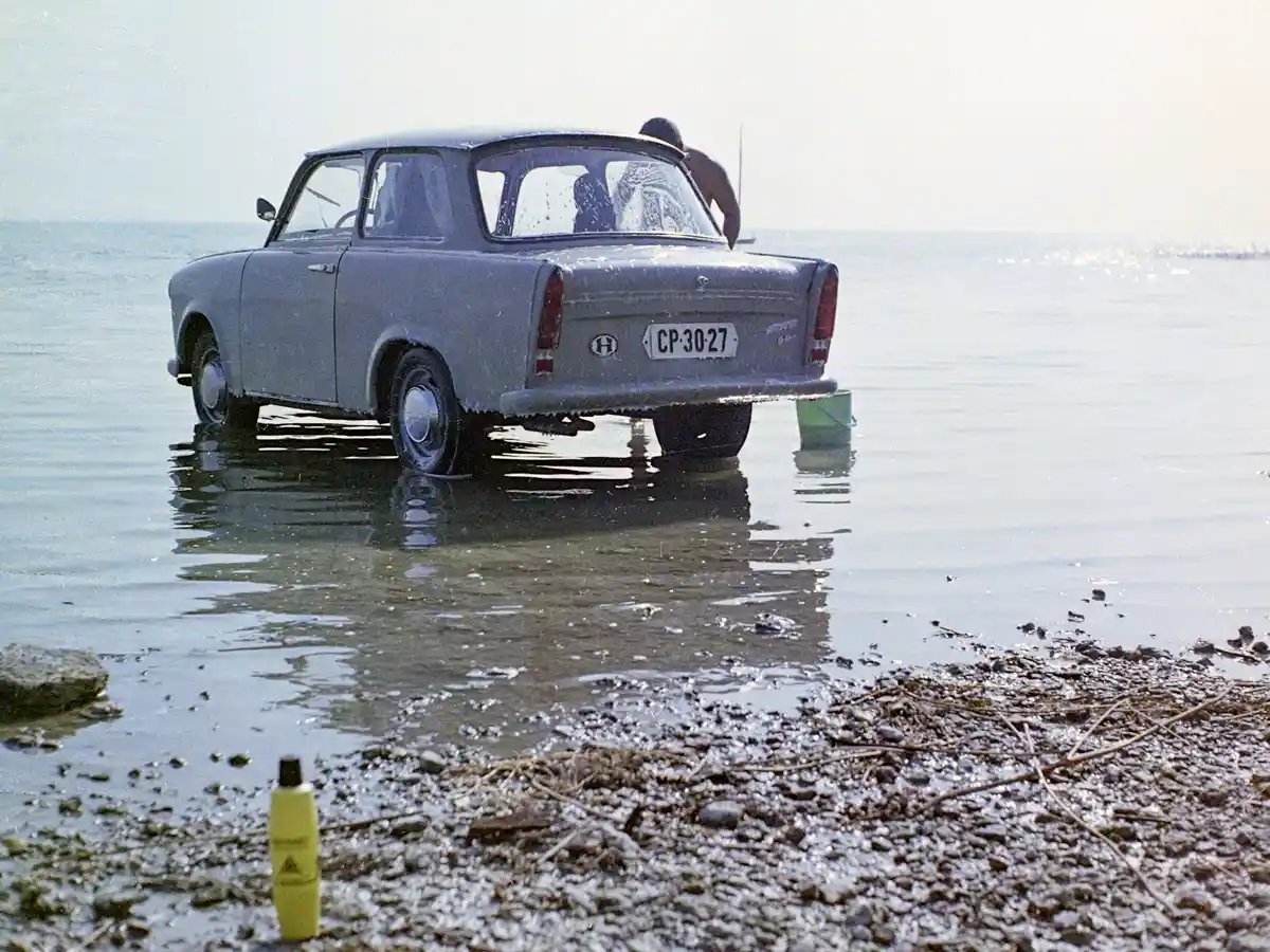 Autóját a Balatonban mosó ember (1971), a sárga flakon AUTONET autósampon, a budapesti Egyesült Vegyiművek terméke (fotó: Fortepan/Uvaterv)