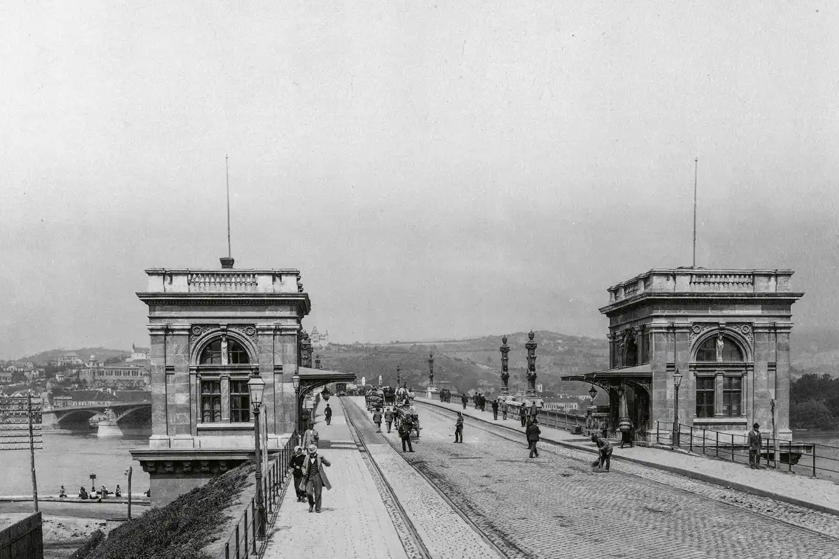 Vámházak a Margit híd pesti oldalán. Buda és Pest között itt 1894-ben kezdődött a villa­mosközlekedés, előtte 1879-től lóvasút járt
